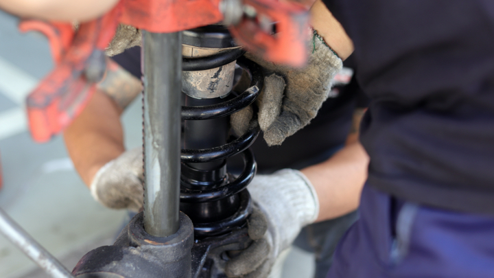 Strut being installed on car.