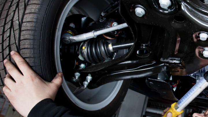 Technician inspecting shocks.