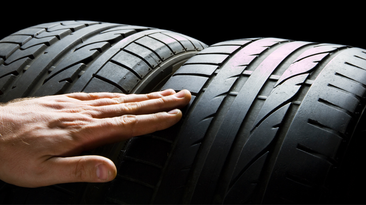 Examining tires for wear.