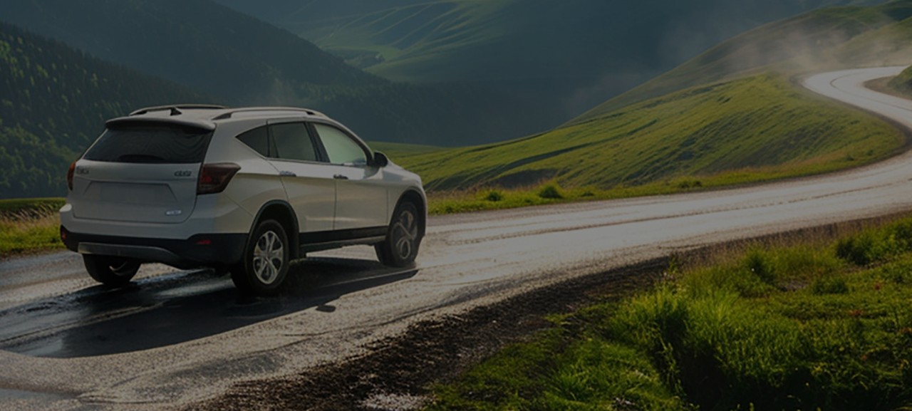 White-SUV-Driving-On-Winding-Road-Hero View from under a vehicle.