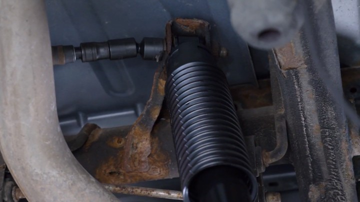 Auto technician torquing shock bolts shock installation.