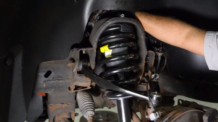 install-struts-chevy-silverado-gmc-sierra-1500-step-5 Technician inserting a new strut assembly